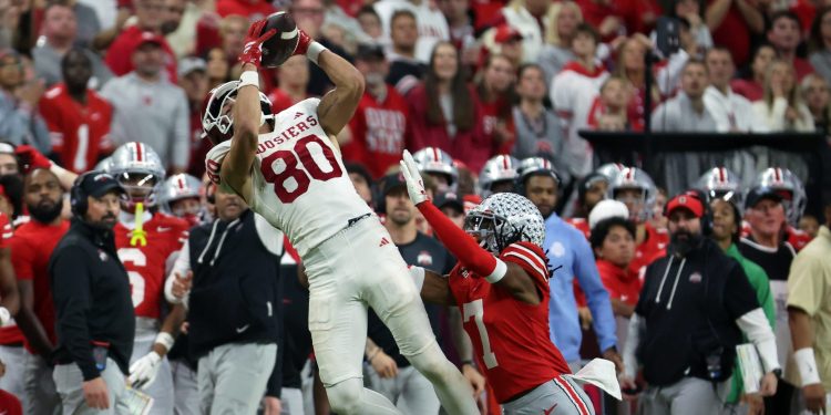Dec 6, 2025; Indianapolis, IN, USA; Indiana Hoosiers wide receiver Charlie Becker (80) makes a catch against Ohio State Buckeyes cornerback Jermaine Mathews Jr. (7) in the fourth quarter during the 2025 Big Ten championship game at Lucas Oil Stadium. Mandatory Credit: Trevor Ruszkowski-Imagn Images