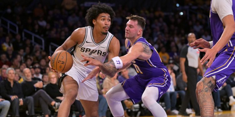Dec 10, 2025; Los Angeles, California, USA;  San Antonio Spurs guard Dylan Harper (2) is defended by Los Angeles Lakers guard Luka Doncic (77) as he drives to the basket during the first half at Crypto.com Arena. Mandatory Credit: Jayne Kamin-Oncea-Imagn Images