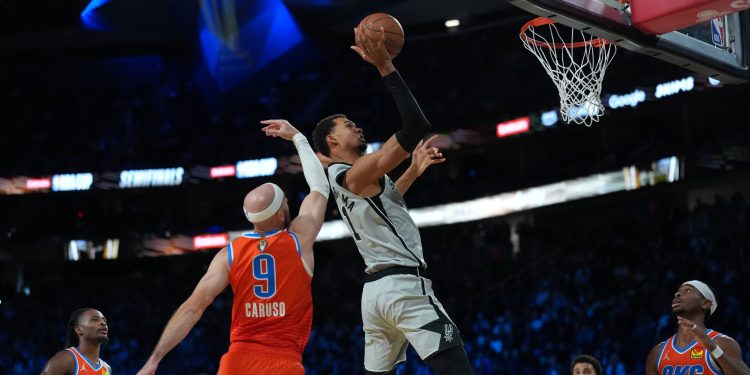 Dec 13, 2025; Las Vegas, Nevada, USA; San Antonio Spurs forward Victor Wembanyama (1) goes to the basket as Oklahoma City Thunder guard Alex Caruso (9) defends during the fourth quarter at T-Mobile Arena. Mandatory Credit: Kirby Lee-Imagn Images