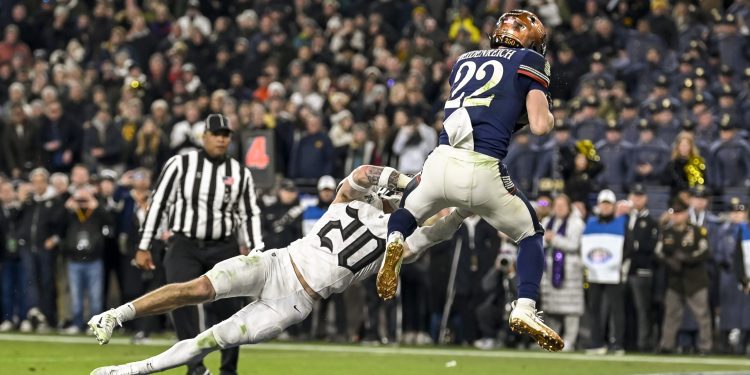Dec 13, 2025; Baltimore, Maryland, USA;  Navy Midshipmen running back Eli Heidenreich (22) catches a touchdown in front of Army West Point Black Knights safety Casey Larkin (20) during the second half  at M&T Bank Stadium. Mandatory Credit: Tommy Gilligan-Imagn Images