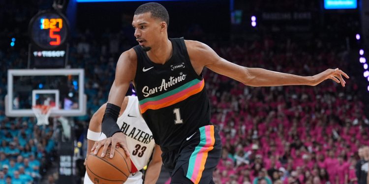 San Antonio Spurs forward Victor Wembanyama (1) drives past Portland Trail Blazers forward Toumani Camara (33) during the second half in Game 1 of a first-round NBA playoffs basketball series in San Antonio, Sunday, April 19, 2026. (AP Photo/Eric Gay)