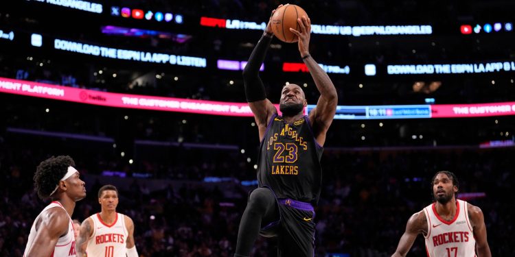 Los Angeles Lakers forward LeBron James, second from right, shoots as Houston Rockets guard Amen Thompson, left, forward Jabari Smith Jr., second from left, and forward Tari Eason defend during the second half in Game 2 of a first-round NBA playoffs basketball series Tuesday, April 21, 2026, in Los Angeles. (AP Photo/Mark J. Terrill)