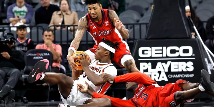 Auburn forward Sebastian Williams-Adams (33) fights for the ball with St. John's forward Dillon Mitchell (1) and guard Joson Sanon (3) during the second half of an NCAA college basketball game in the Players Era tournament Wednesday, Nov. 26, 2025, in Las Vegas. (AP Photo/Steve Marcus)