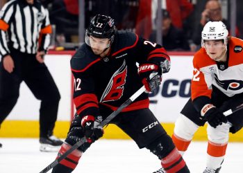 Carolina Hurricanes' Logan Stankoven (22) controls the puck in front of Philadelphia Flyers' Denver Barkey (52) during the first period of Game 1 of an NHL hockey Stanley Cup second-round playoff series in Raleigh, N.C., Saturday, May 2, 2026. (AP Photo/Karl DeBlaker)