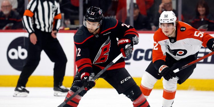 Carolina Hurricanes' Logan Stankoven (22) controls the puck in front of Philadelphia Flyers' Denver Barkey (52) during the first period of Game 1 of an NHL hockey Stanley Cup second-round playoff series in Raleigh, N.C., Saturday, May 2, 2026. (AP Photo/Karl DeBlaker)