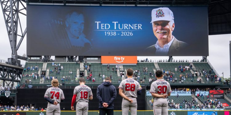 Atlanta Braves including Jim Jarvis (74), Mike Yastrzemski (18), Matt Olson (28) and Drake Baldwin (30) stand of the field during a moment of silence for Ted Turner before a baseball game against the Seattle Mariners, Wednesday, May 6, 2026, in Seattle. (AP Photo/Stephen Brashear)