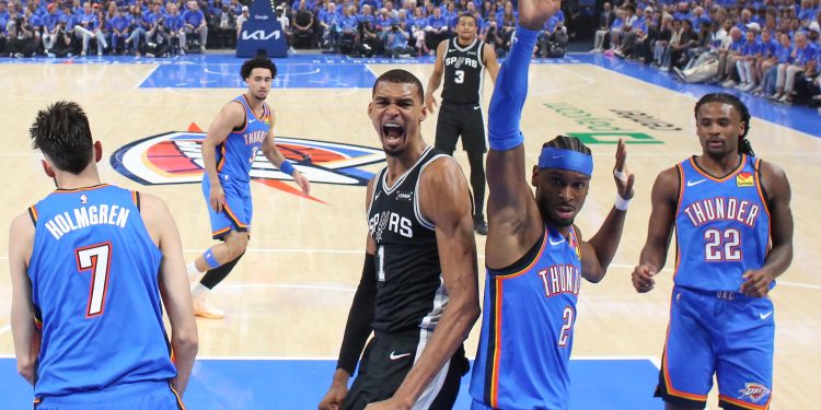 San Antonio Spurs forward Victor Wembanyama (1) reacts next to Oklahoma City Thunder guard Shai Gilgeous-Alexander (2) after a dunk during the first half in Game 1 of the Western Conference finals NBA basketball playoffs series Monday, May 18, 2026, in Oklahoma City. (AP Photo/Nate Billings)