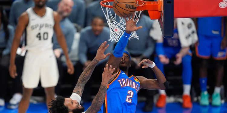 Oklahoma City Thunder guard Shai Gilgeous-Alexander (2) defends against San Antonio Spurs forward Julian Champagnie (30) during the second half of Game 2 in the Western Conference finals NBA basketball playoffs series Wednesday, May 20, 2026, in Oklahoma City. (AP Photo/Tony Gutierrez)