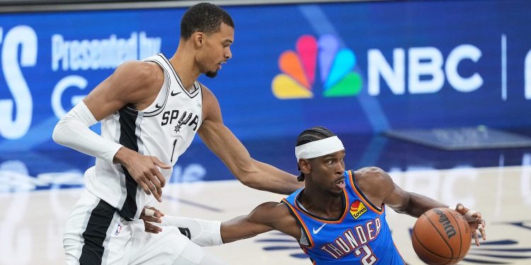 Oklahoma City Thunder guard Shai Gilgeous-Alexander (2) is challenged by San Antonio Spurs forward Victor Wembanyama (1) during the first half of Game 4 in the Western Conference finals NBA basketball playoffs series in San Antonio, Sunday, May 24, 2026. (AP Photo/Eric Gay)