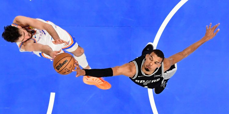 San Antonio Spurs forward Victor Wembanyama, right, blocks a shot by Oklahoma City Thunder center Chet Holmgren during the first half in Game 5 in the Western Conference finals NBA basketball playoffs series, Tuesday, May 26, 2026, in Oklahoma City. (AP Photo/Gerald Leong)