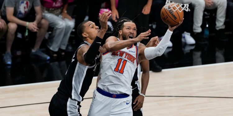 New York Knicks guard Jalen Brunson (11) drives past San Antonio Spurs forward Victor Wembanyama, left, during the first half of Game 1 of the NBA Finals basketball series, Wednesday, June 3, 2026, in San Antonio. (AP Photo/David J. Phillip)