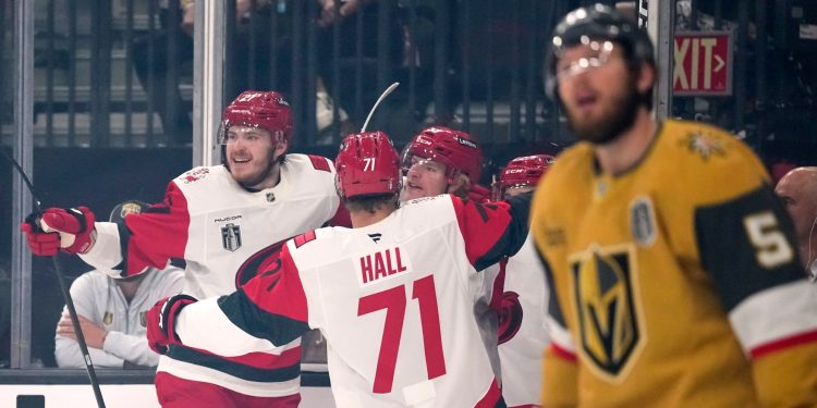 Carolina Hurricanes right wing Jackson Blake, second from right, celebrates his goal with defenseman Alexander Nikishin, left, and left wing Taylor Hall, second from left, as Vegas Golden Knights defenseman Jeremy Lauzon looks on during the first period in Game 4 of the NHL hockey Stanley Cup Final series Tuesday, June 9, 2026, in Las Vegas. (AP Photo/John Locher)