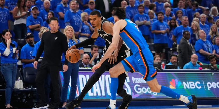 San Antonio Spurs forward Victor Wembanyama, left, works against Oklahoma City Thunder center Chet Holmgren, right, during Game 1 of the Western Conference finals of the NBA basketball playoffs Monday, May 18, 2026, in Oklahoma City. (AP Photo/Tony Gutierrez)