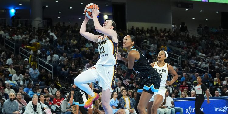Indiana Fever guard Caitlin Clark, center left, drives to the basket past Chicago Sky forward/center Azura Stevens, center right, during the first half of a WNBA basketball game Sunday, Aug. 23, 2026, in Chicago. (AP Photo/Nam Y. Huh)