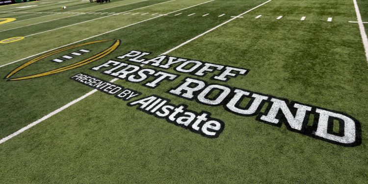 A playoff logo decorates the field before the first round of the NCAA College Football Playoff between Oregon and James Madison, Saturday, Dec. 20, 2025, in Eugene, Ore. (AP Photo/Lydia Ely)