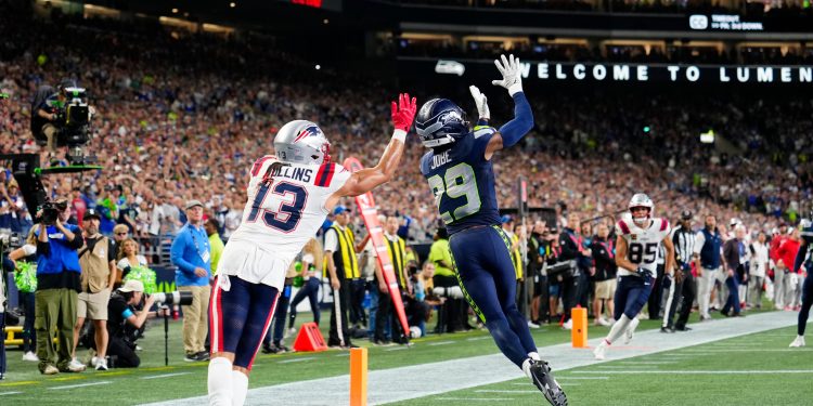 Seattle Seahawks cornerback Josh Jobe (29) intercepts the ball in front of New England Patriots wide receiver Mack Hollins (13) during an NFL football game in Seattle, Wednesday, Sept. 9, 2026. (AP Photo/Ben VanHouten)