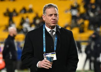 Broadcaster and former NFL quarterback Troy Aikman walks on the field before an NFL wild-card playoff football game between the Houston Texans and the Pittsburgh Steelers, Monday, Jan. 12, 2026, in Pittsburgh. (AP Photo/Justin Berl)