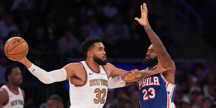 New York Knicks center Karl-Anthony Towns (32) looks to pass as Philadelphia 76ers forward LeBron James (23) defends during the second half of an NBA basketball game Tuesday, Oct. 20, 2026, in New York. (AP Photo/Frank Franklin II)
