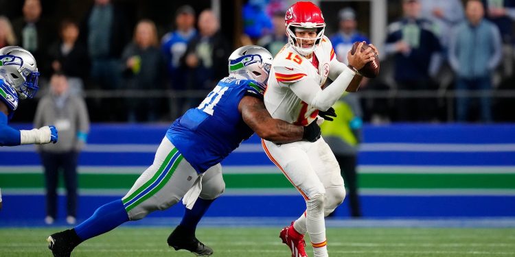 Seattle Seahawks nose tackle Byron Murphy II (91) attempts to sack Kansas City Chiefs quarterback Patrick Mahomes (15) during an NFL football game in Seattle, Sunday, Oct. 25, 2026. (AP Photo/Ben VanHouten)